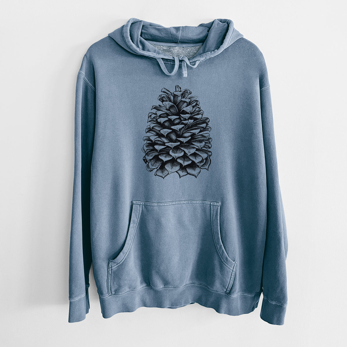 Slate blue pigment dyed hoodie laid flat, printed with a detailed black ink illustration of a large Jeffrey pine cone.