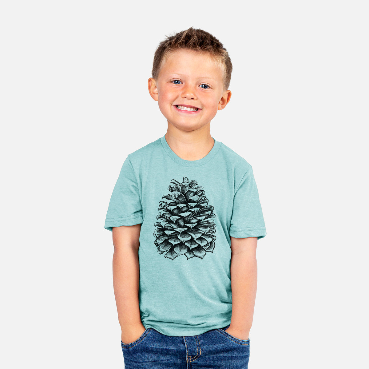 Smiling boy wearing a youth t-shirt printed with a detailed black ink illustration of a large Jeffrey pine cone.
