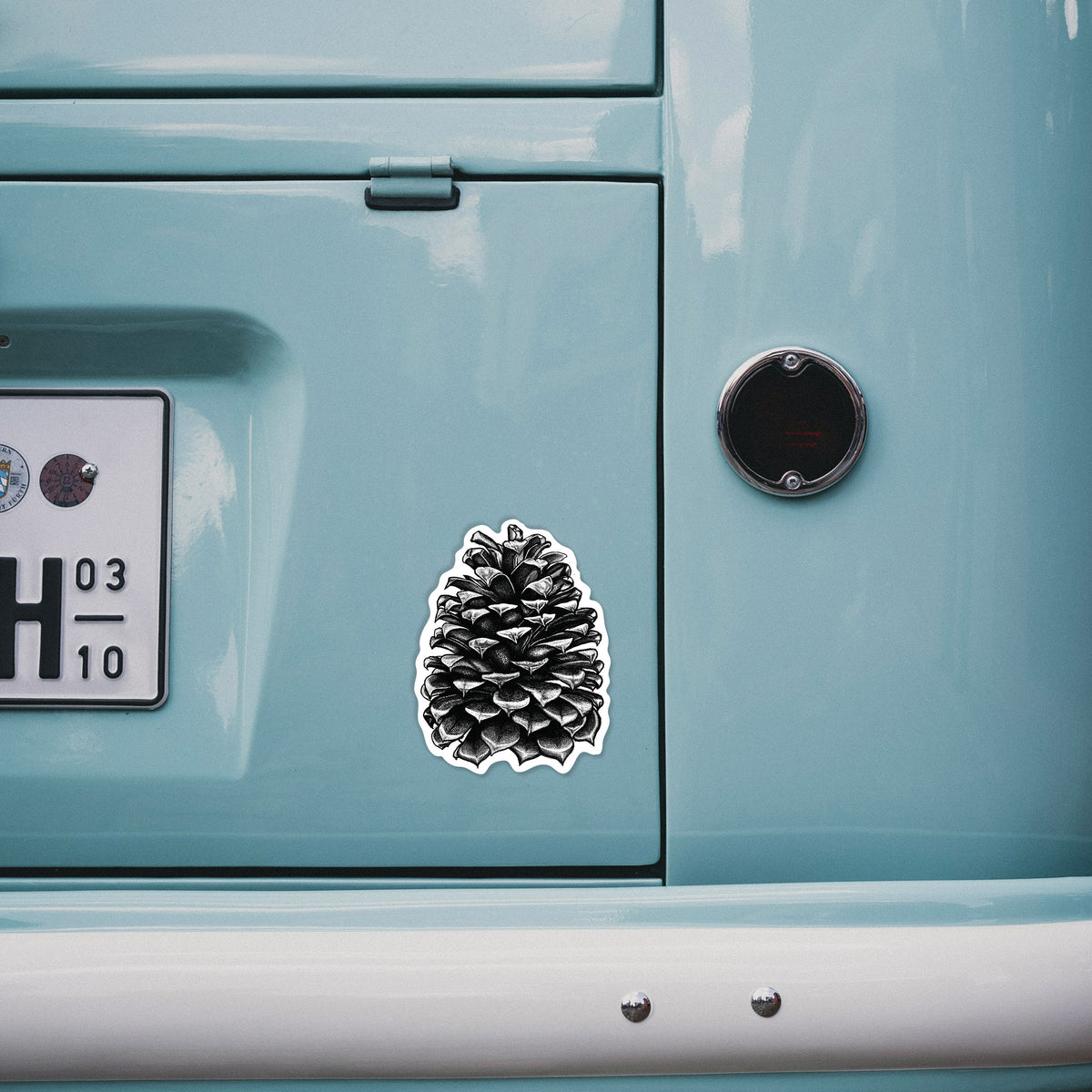 4 inch vinyl decal of a detailed black ink illustration of a large Jeffrey pine cone on the back of a van.