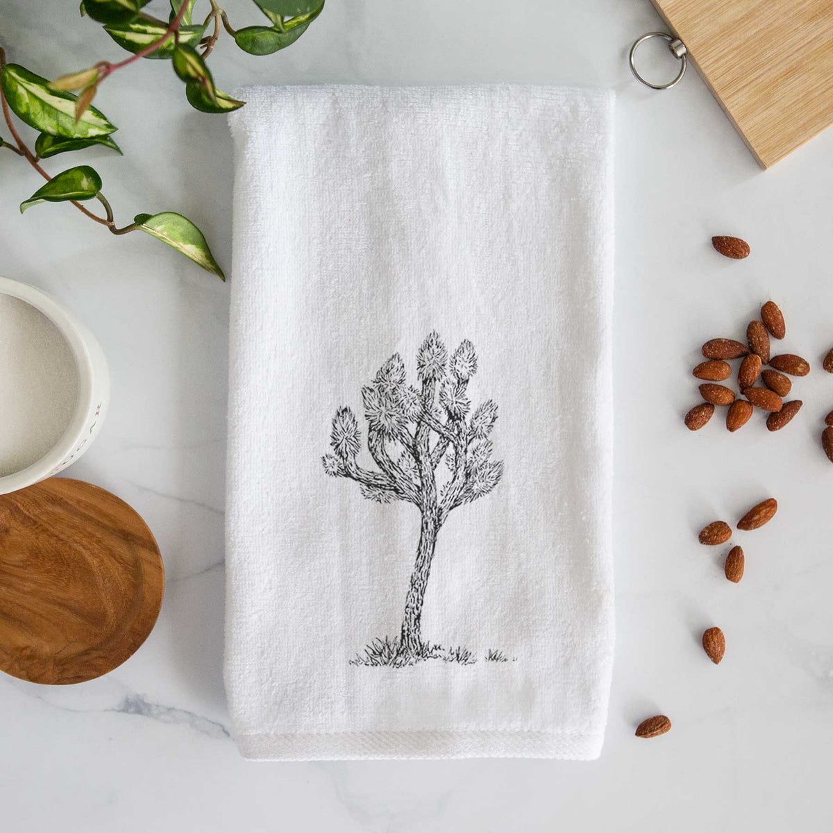 White hand towel printed with a detailed black ink illustration of a Joshua tree.