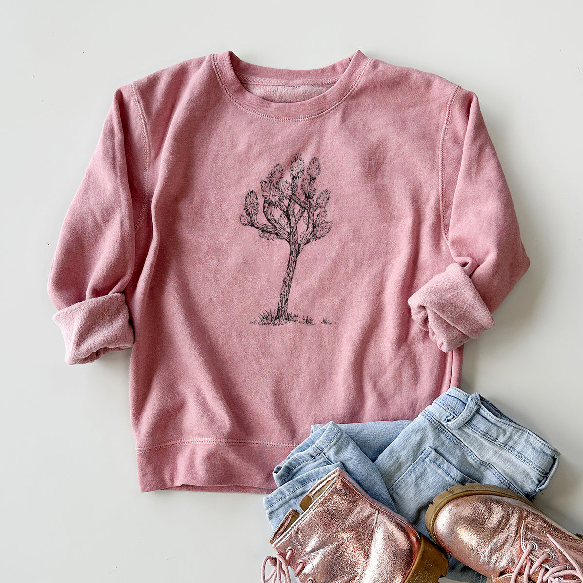Youth crewneck sweatshirt printed with a detailed black ink illustration of a Joshua tree, styled flat with jeans and boots.