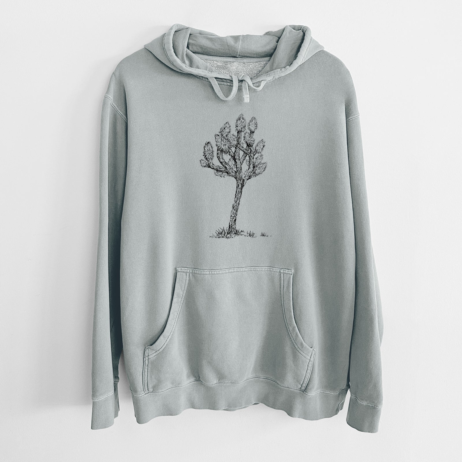 Sage green pigment dyed hoodie laid flat, printed with a detailed black ink illustration of a Joshua tree.