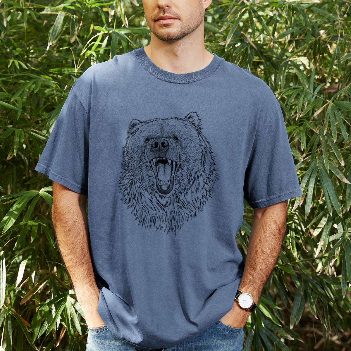 Man wearing a Comfort Colors t-shirt printed with a detailed black ink portrait of a roaring Kodiak bear facing forward, outdoors.