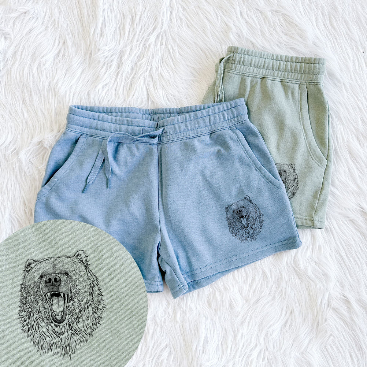 Two pairs of Cali Wave shorts in different colors printed with a detailed black ink portrait of a roaring Kodiak bear facing forward, with a close-up of the print.