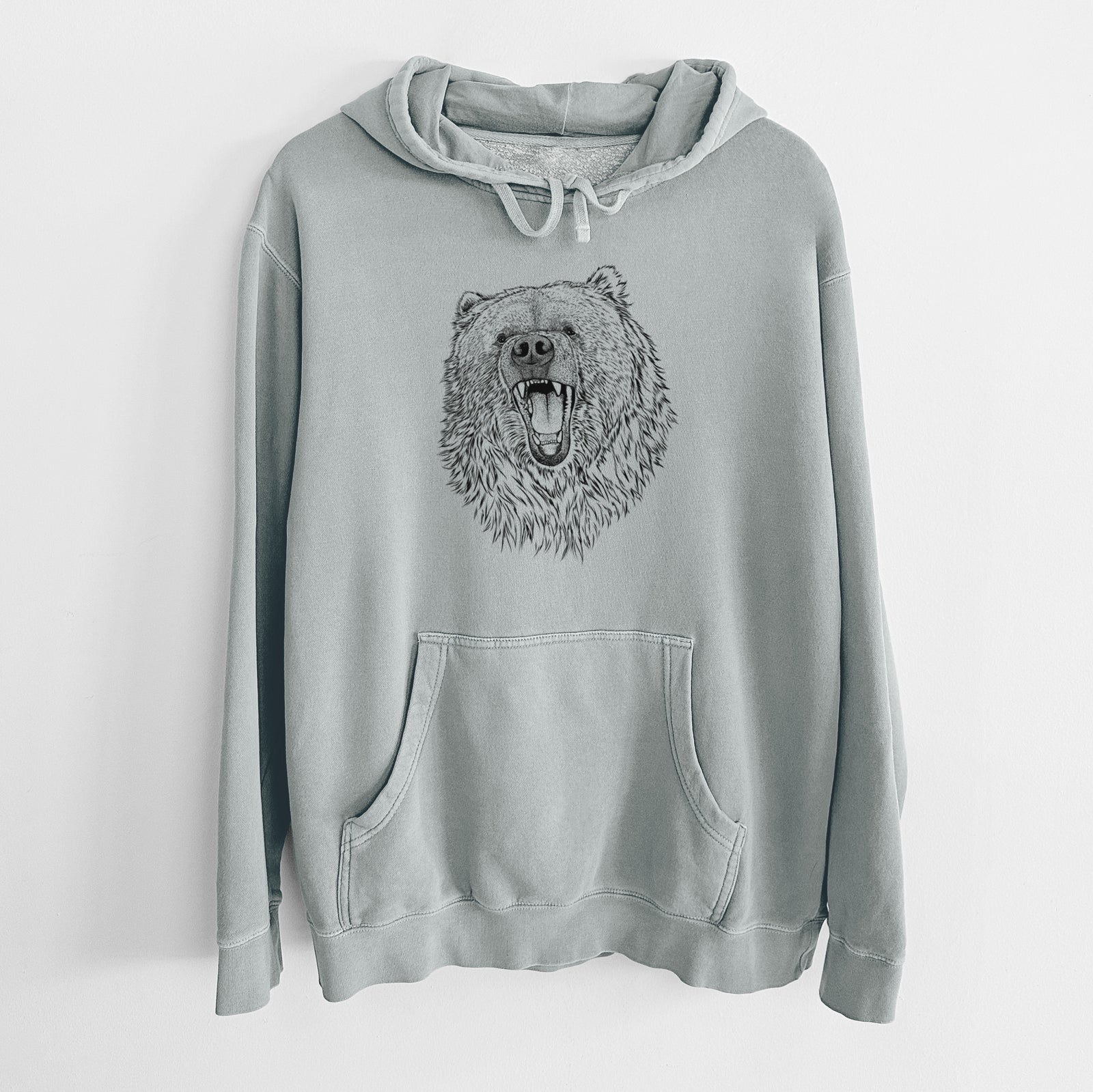 Sage green pigment dyed hoodie laid flat, printed with a detailed black ink portrait of a roaring Kodiak bear facing forward.