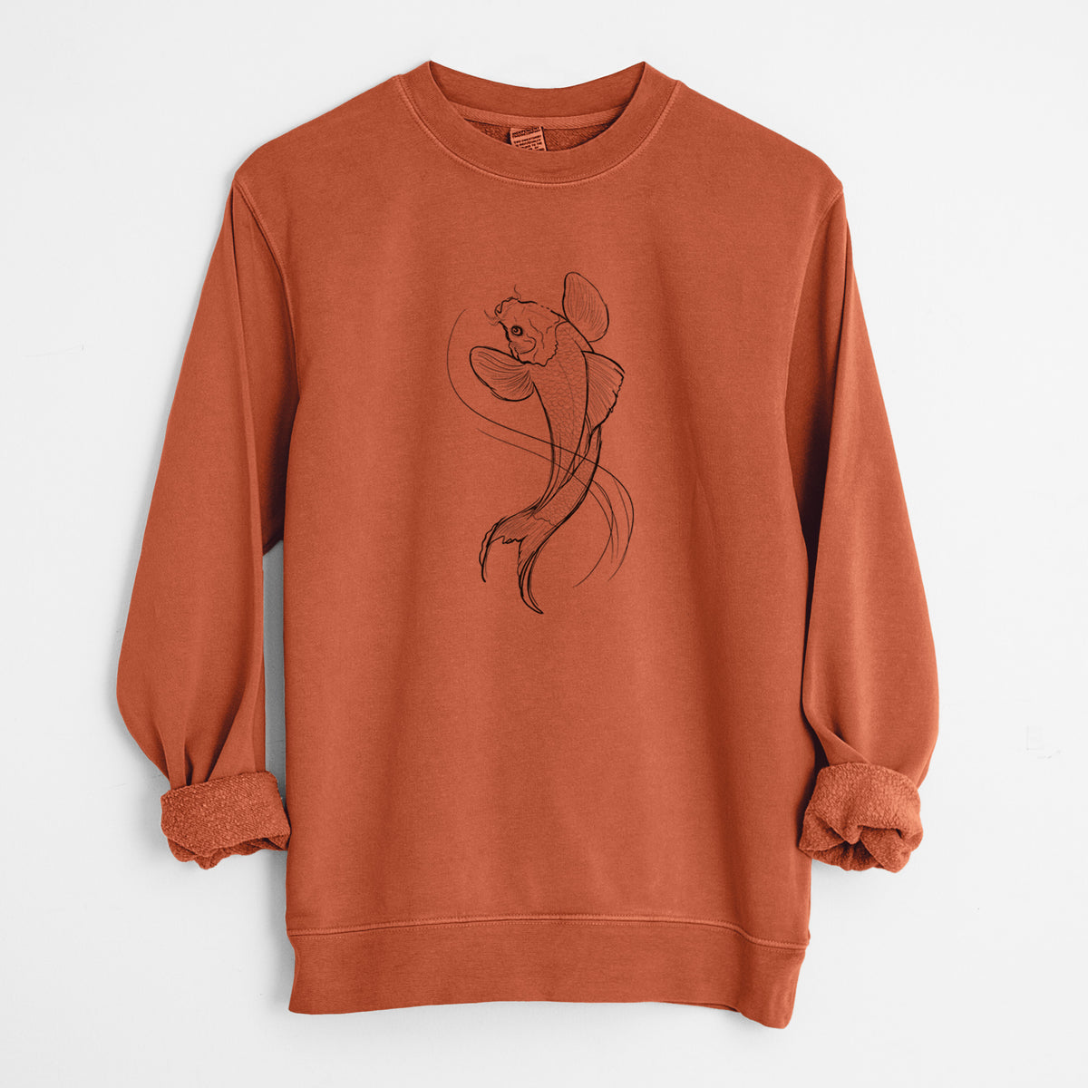Amber orange pigment dyed crewneck sweatshirt laid flat with the sleeves rolled, printed with a black ink line drawing of a koi fish swimming with flowing fins.