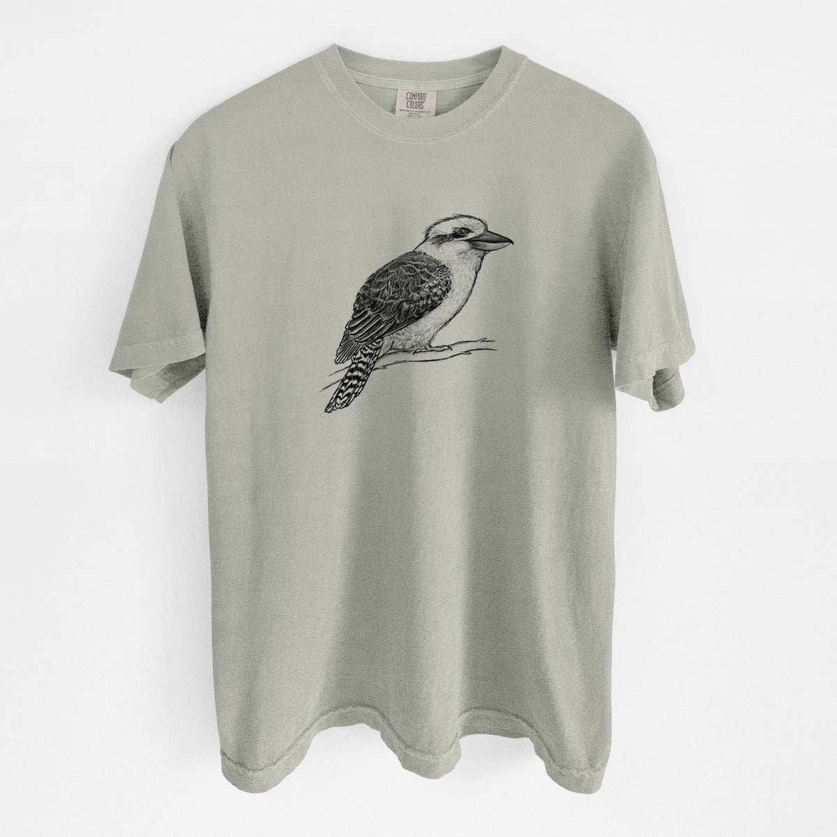 Sandstone beige Comfort Colors t-shirt laid flat, printed with a detailed black ink sketch of a kookaburra perched on a branch.