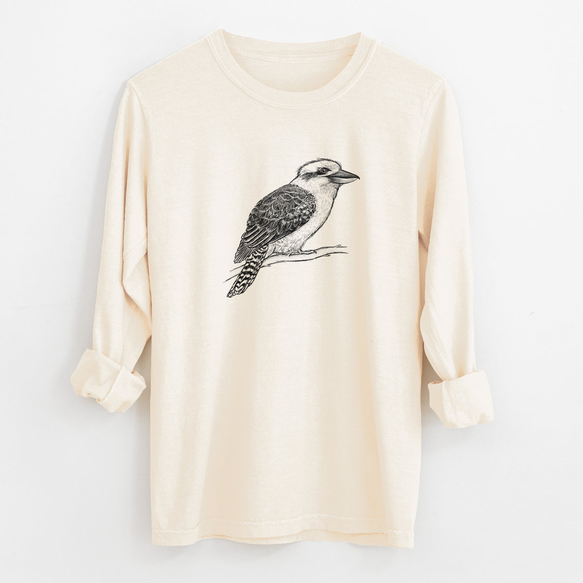 Ivory Comfort Colors long sleeve shirt laid flat with the cuffs rolled, printed with a detailed black ink sketch of a kookaburra perched on a branch.