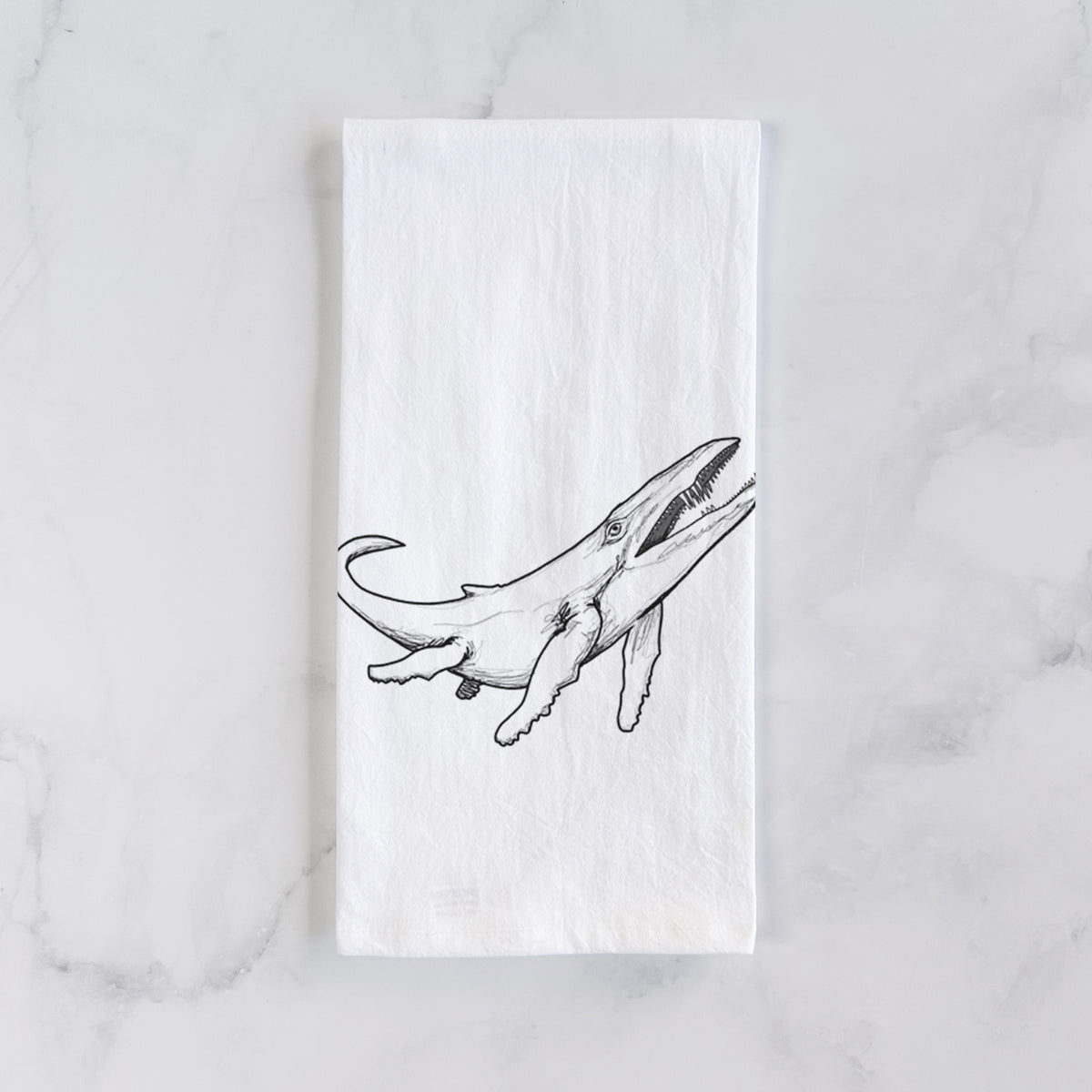 White cotton tea towel laid flat on marble, printed with a black ink illustration of a Kronosaurus marine reptile swimming.