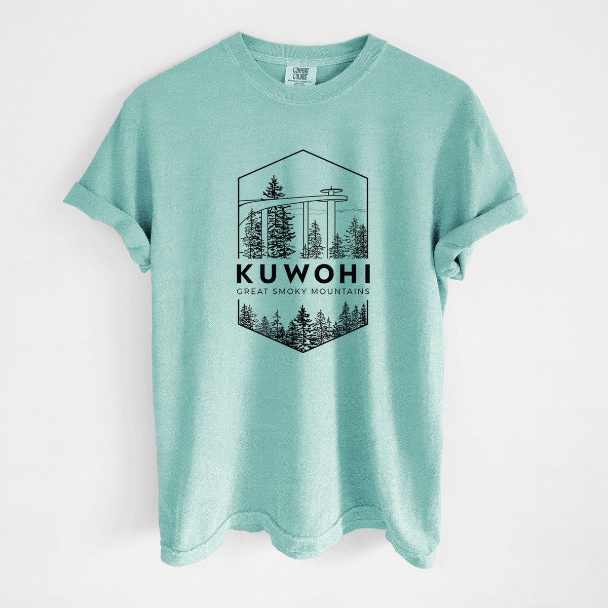 Chalky mint Comfort Colors t-shirt laid flat, printed with a black line art badge of the Kuwohi observation tower above pine trees, with the words Kuwohi, Great Smoky Mountains.