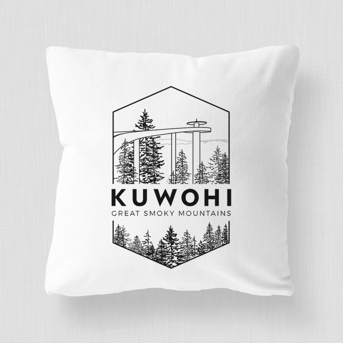 White pillow cover printed with a black line art badge of the Kuwohi observation tower above pine trees, with the words Kuwohi, Great Smoky Mountains.