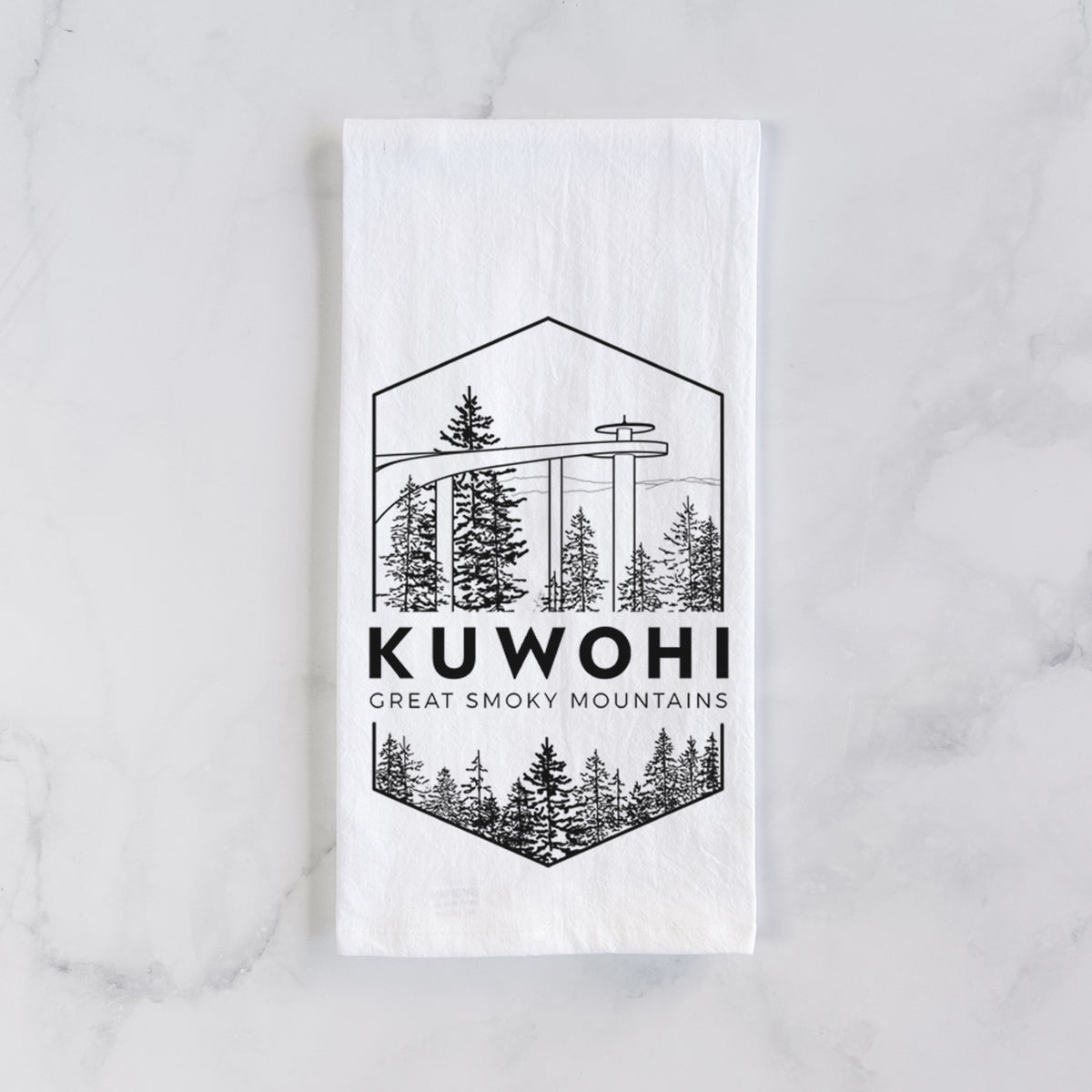 White cotton tea towel laid flat on marble, printed with a black line art badge of the Kuwohi observation tower above pine trees, with the words Kuwohi, Great Smoky Mountains.