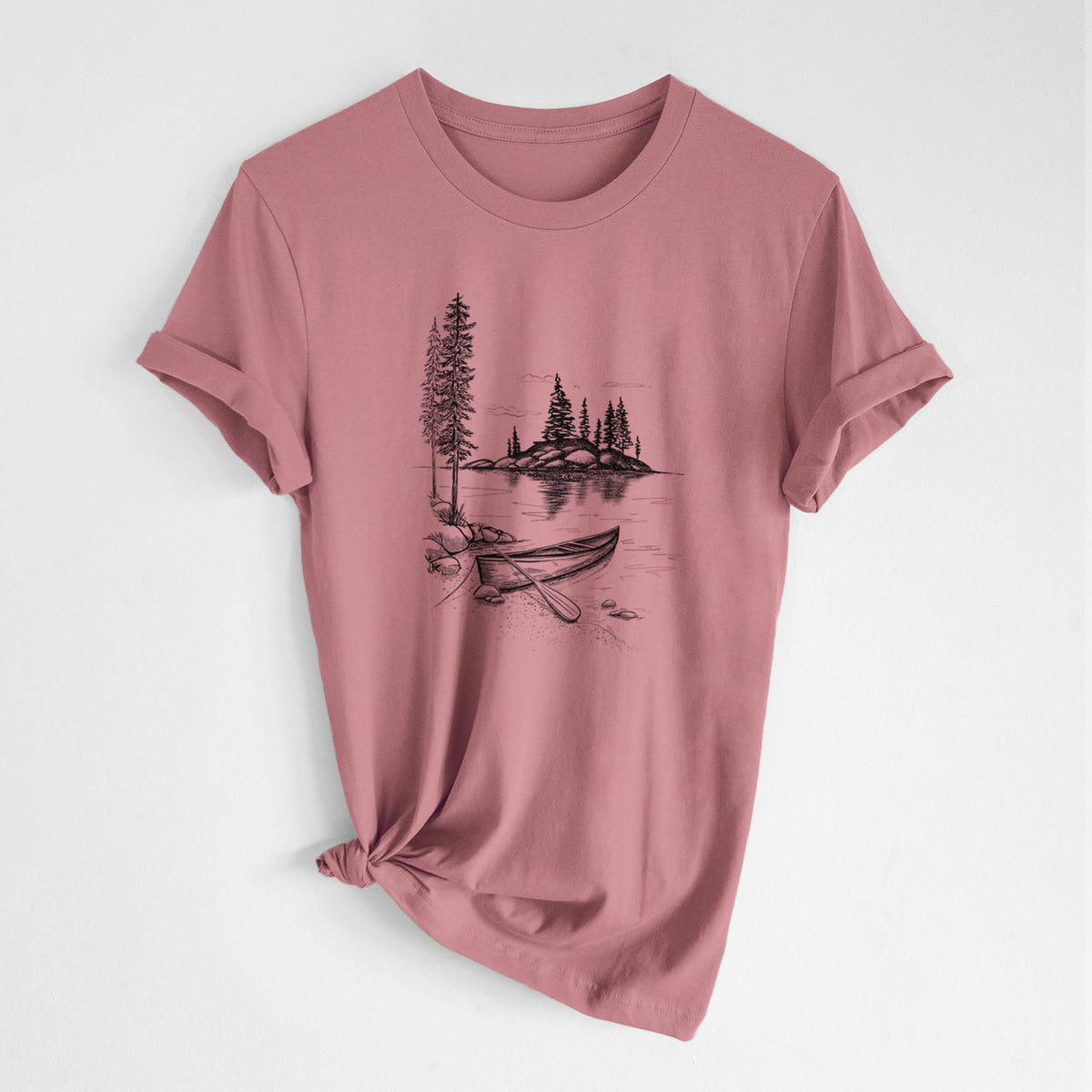 Mauve pink lightweight cotton t-shirt laid flat with the sleeves rolled, printed with a black ink illustration of a canoe resting on the shore of a lake with pine trees on a small island.