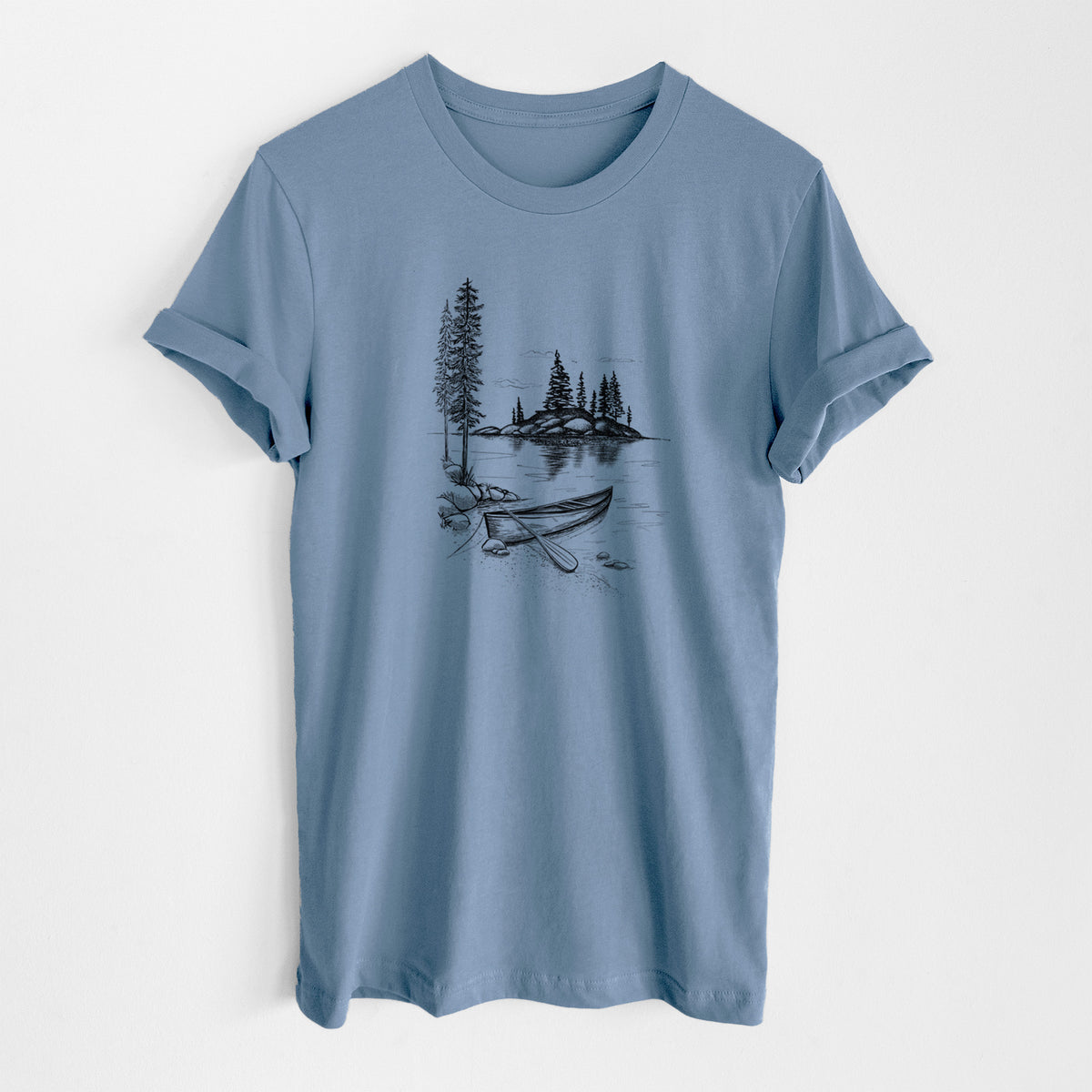Steel blue lightweight cotton t-shirt laid flat, printed with a black ink illustration of a canoe resting on the shore of a lake with pine trees on a small island.