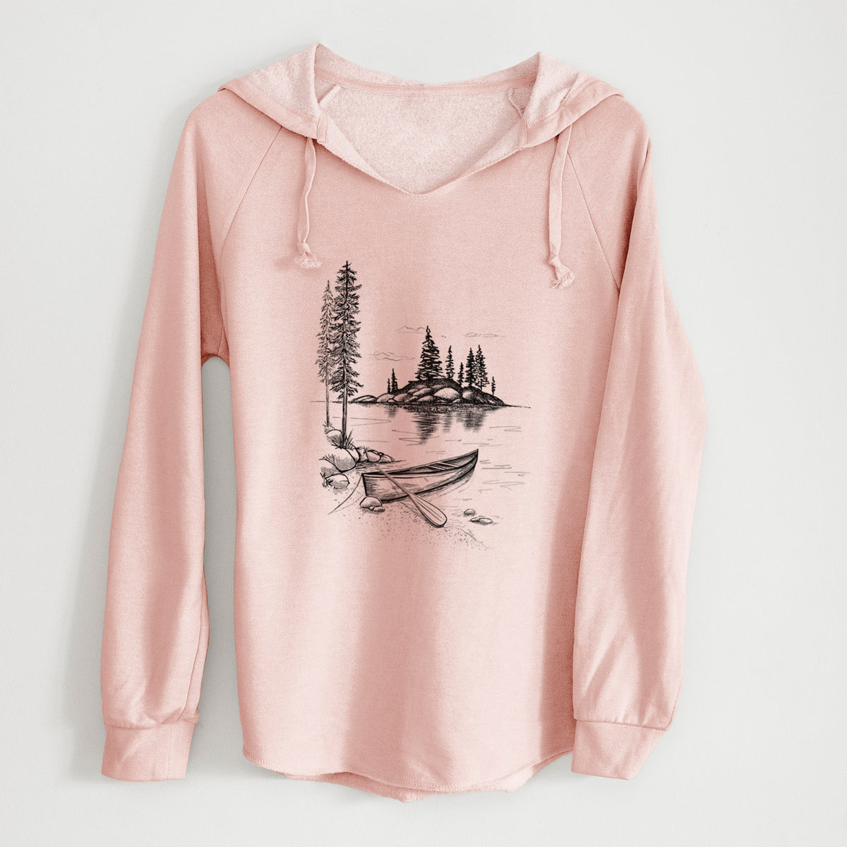 Blush pink women's Cali Wave hooded sweatshirt laid flat, printed with a black ink illustration of a canoe resting on the shore of a lake with pine trees on a small island.