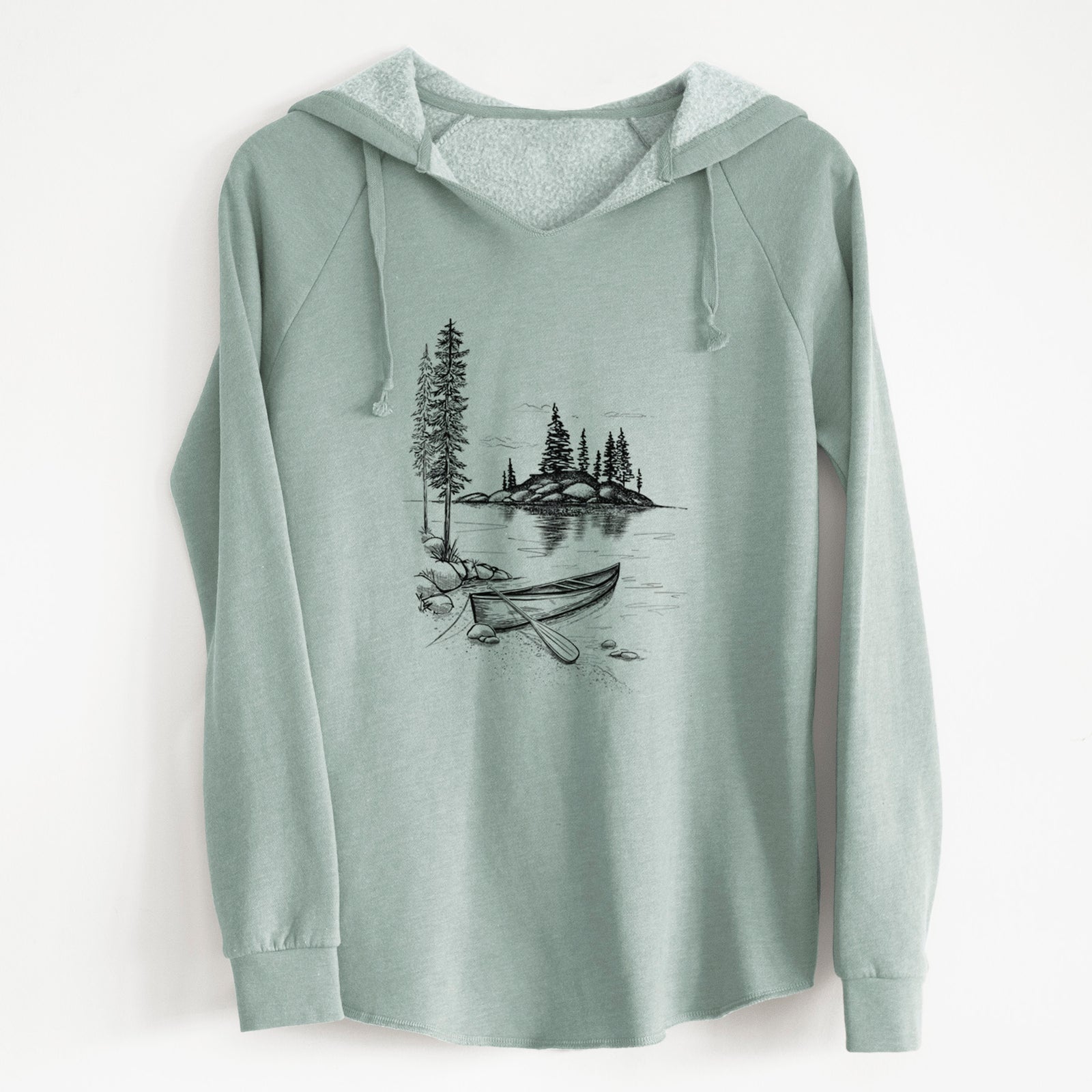Sage green women's Cali Wave hooded sweatshirt laid flat, printed with a black ink illustration of a canoe resting on the shore of a lake with pine trees on a small island.