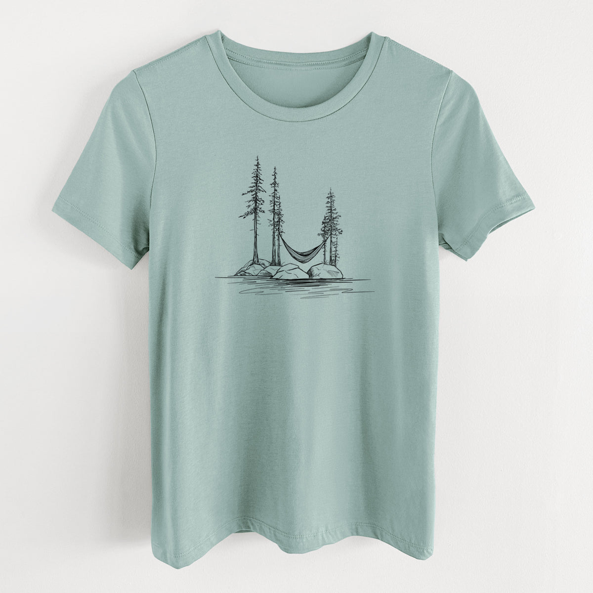 Dusty blue women's relaxed fit cotton t-shirt laid flat, printed with a black ink illustration of a hammock strung between pine trees on a small lakeside island.