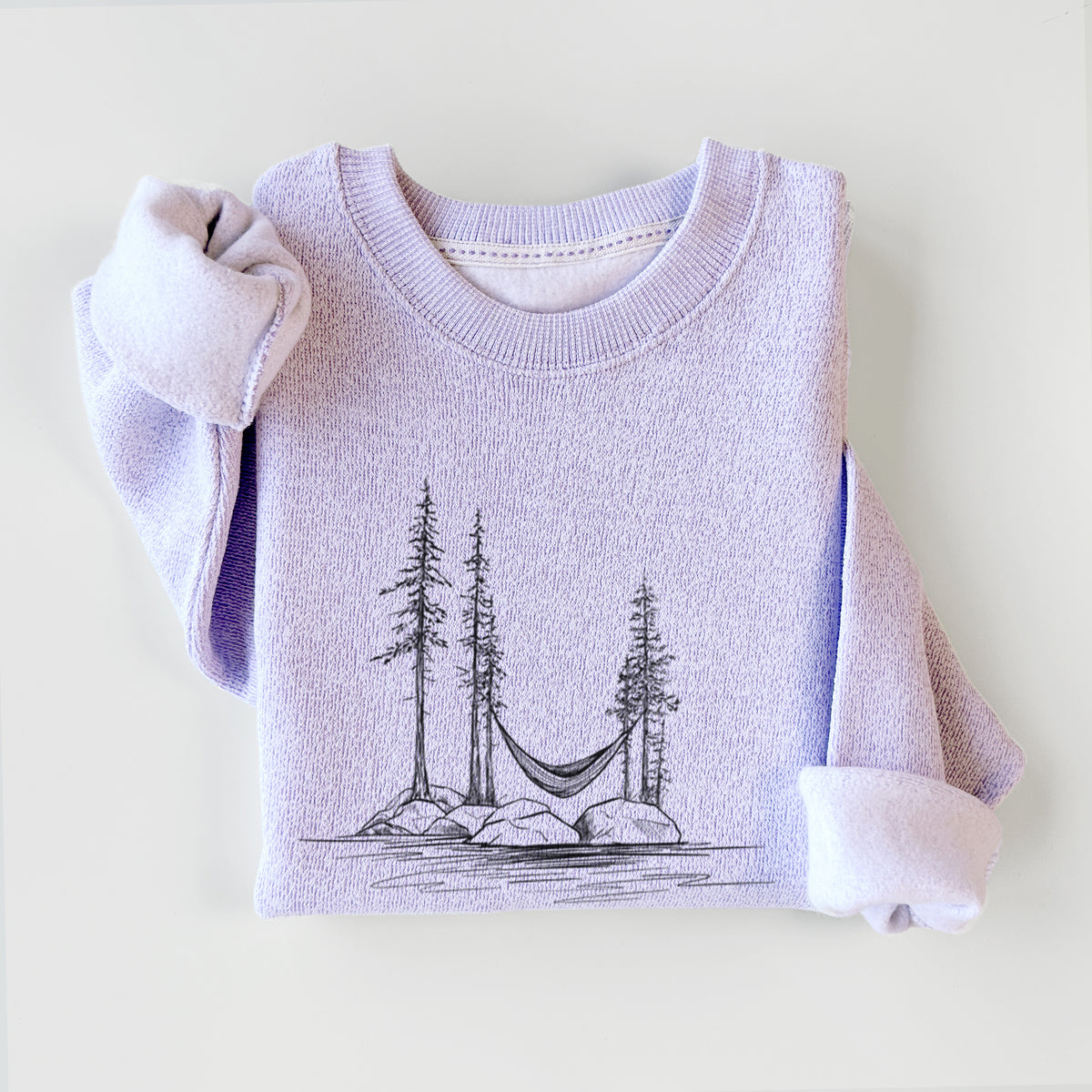 Ice purple knit sweatshirt printed with a black ink illustration of a hammock strung between pine trees on a small lakeside island, styled flat.