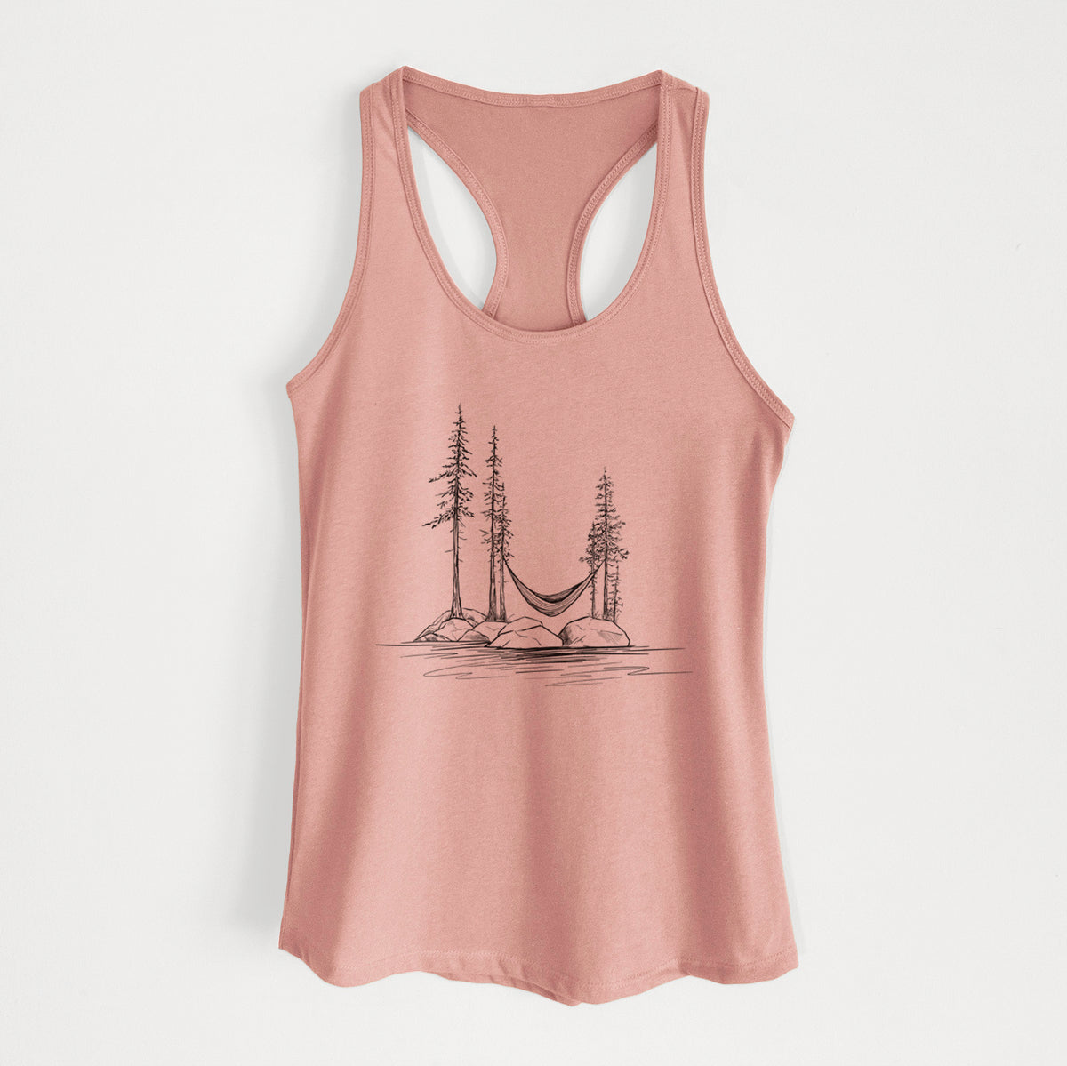 Desert pink women's racerback tank top laid flat, printed with a black ink illustration of a hammock strung between pine trees on a small lakeside island.