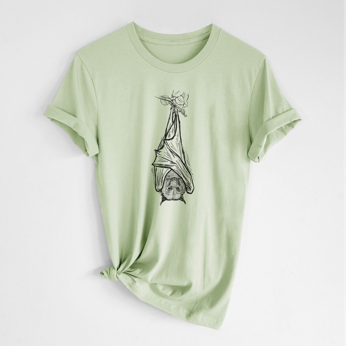 Spring green lightweight cotton t-shirt laid flat with the sleeves rolled, printed with a black ink illustration of a large flying fox bat hanging upside down with its wings wrapped around it.