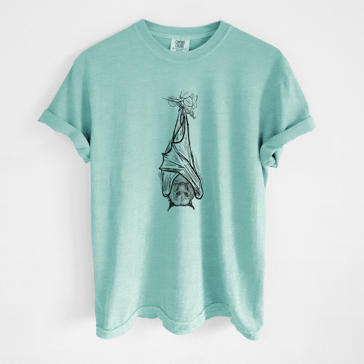 Chalky mint Comfort Colors t-shirt laid flat, printed with a black ink illustration of a large flying fox bat hanging upside down with its wings wrapped around it.