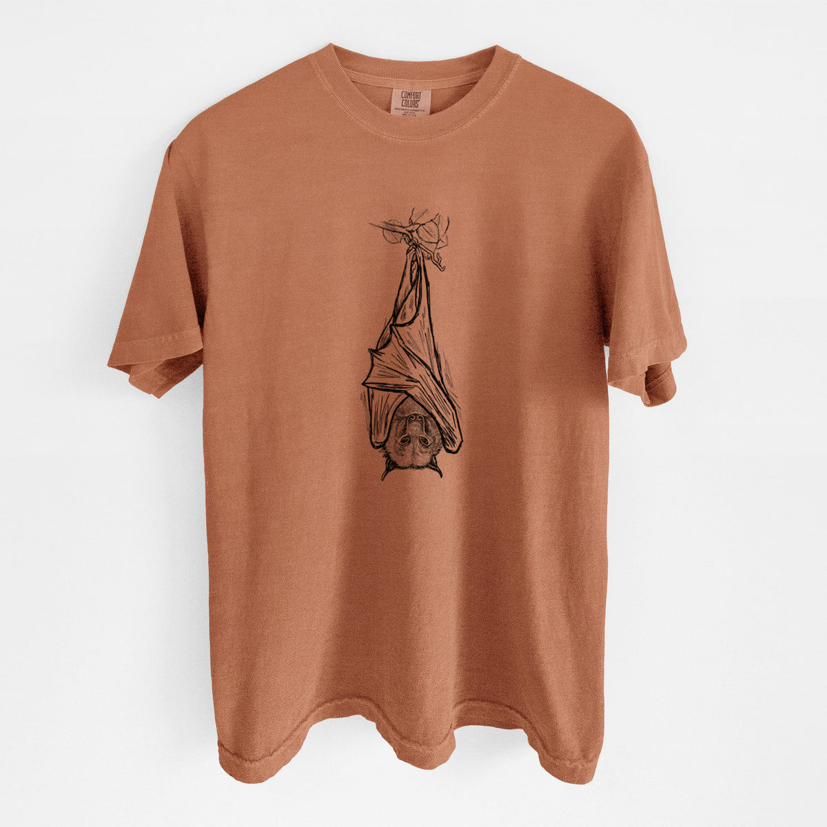 Yam burnt orange Comfort Colors t-shirt laid flat, printed with a black ink illustration of a large flying fox bat hanging upside down with its wings wrapped around it.