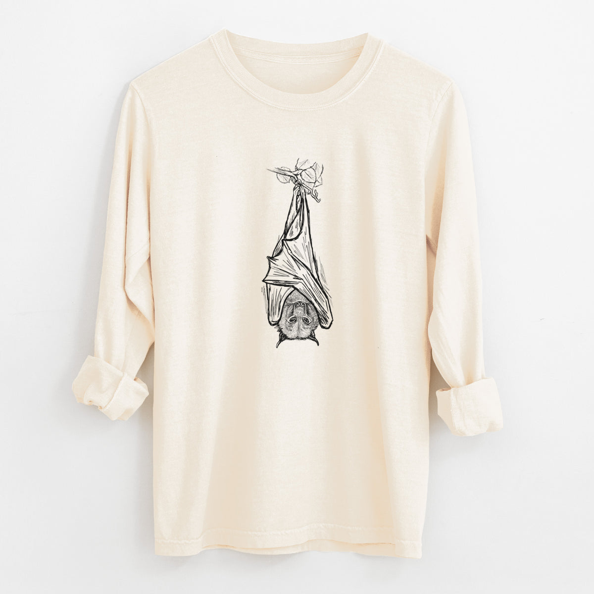Ivory Comfort Colors long sleeve shirt laid flat with the cuffs rolled, printed with a black ink illustration of a large flying fox bat hanging upside down with its wings wrapped around it.