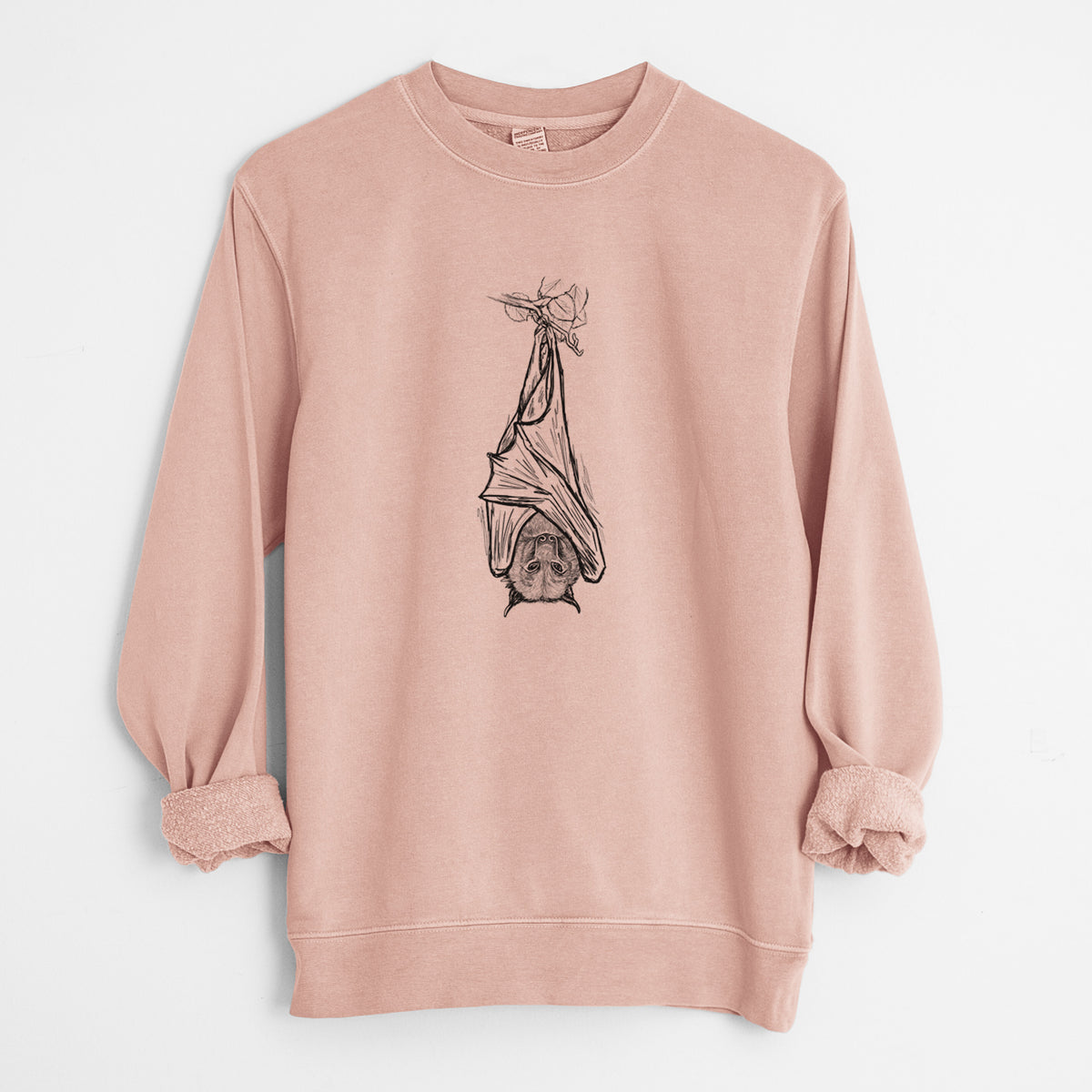 Dusty pink pigment dyed crewneck sweatshirt laid flat with the sleeves rolled, printed with a black ink illustration of a large flying fox bat hanging upside down with its wings wrapped around it.