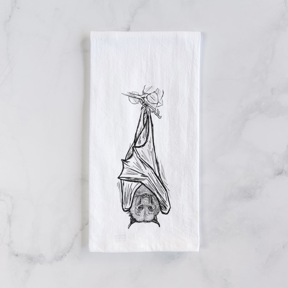 White cotton tea towel laid flat on marble, printed with a black ink illustration of a large flying fox bat hanging upside down with its wings wrapped around it.