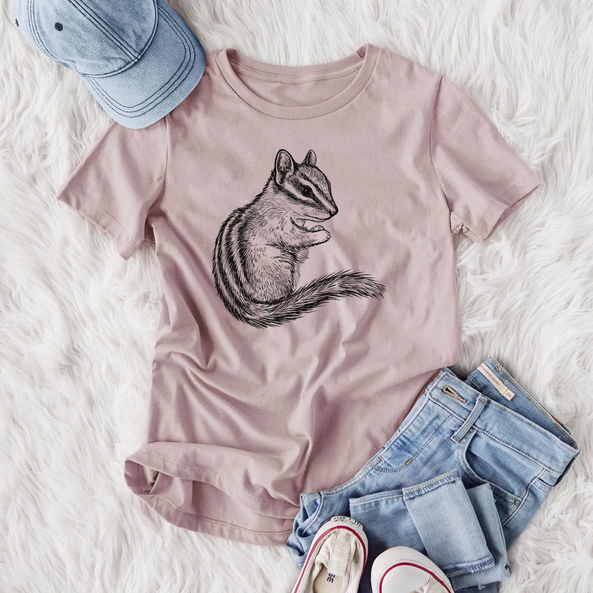 Women's relaxed fit cotton t-shirt printed with a detailed black ink illustration of a least chipmunk sitting and holding food in its paws, styled flat on a white faux fur rug with jeans.
