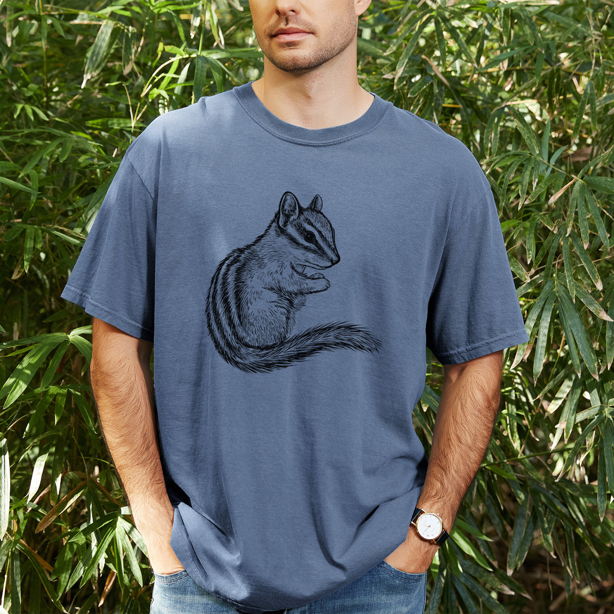 Man wearing a Comfort Colors t-shirt printed with a detailed black ink illustration of a least chipmunk sitting and holding food in its paws, outdoors.