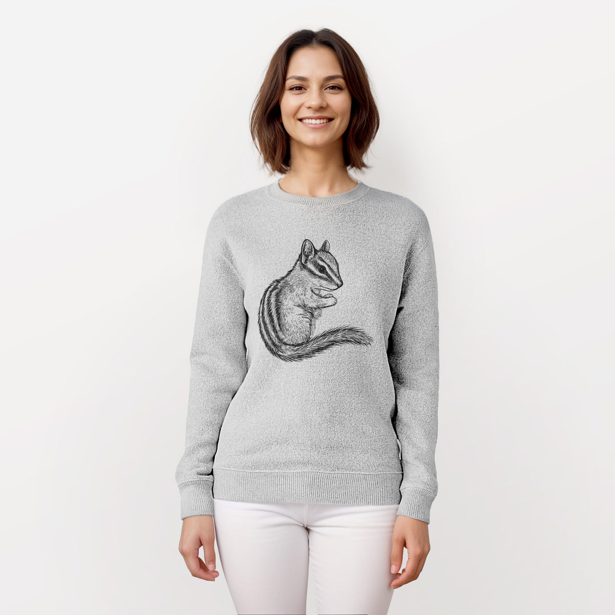 Woman wearing a knit sweatshirt printed with a detailed black ink illustration of a least chipmunk sitting and holding food in its paws.
