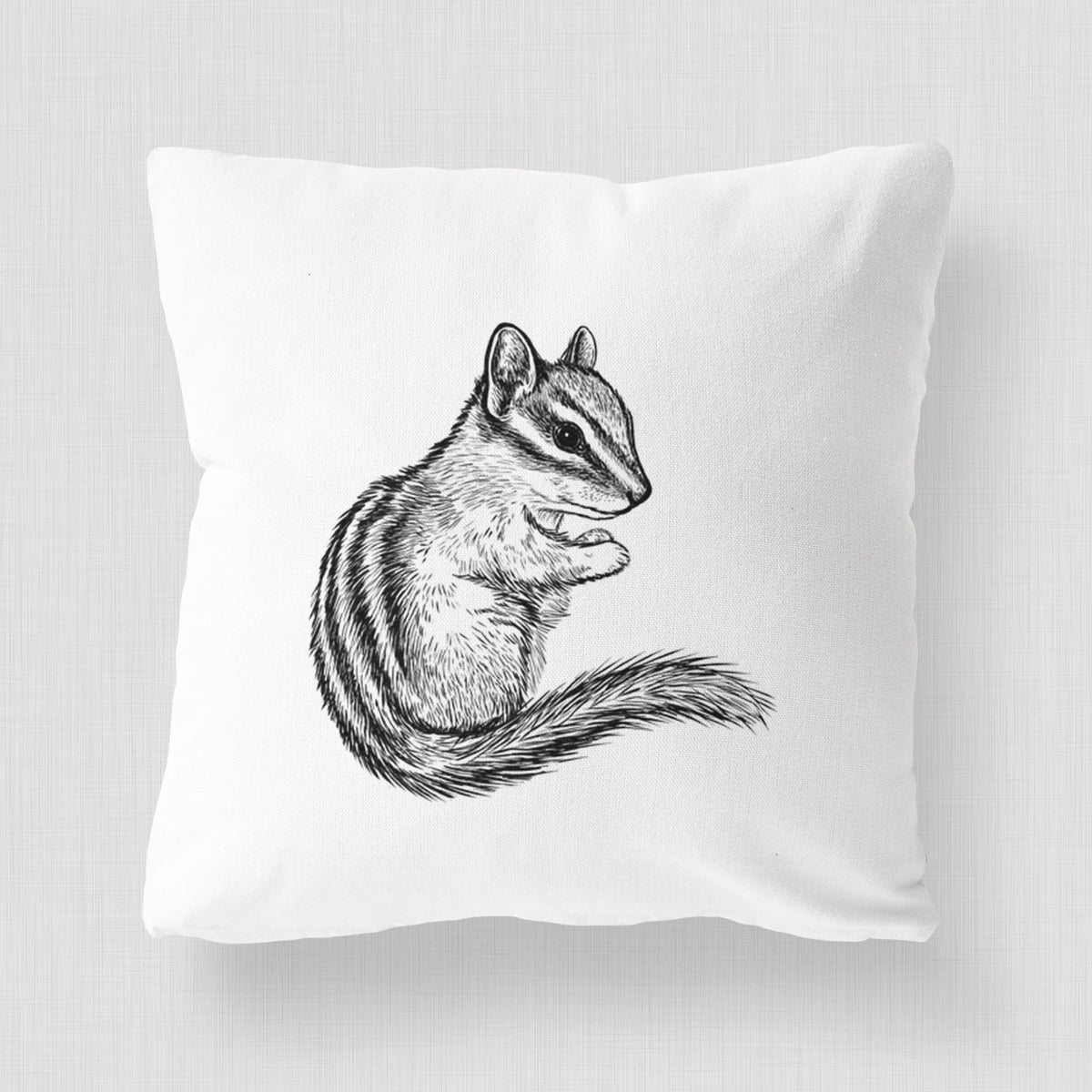 White pillow cover printed with a detailed black ink illustration of a least chipmunk sitting and holding food in its paws.