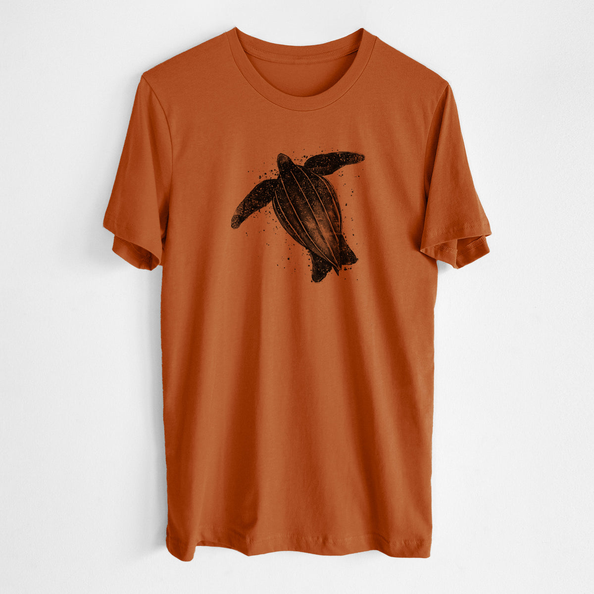 Autumn lightweight cotton t-shirt laid flat, printed with a black ink illustration of a leatherback sea turtle swimming, with ink splatters.
