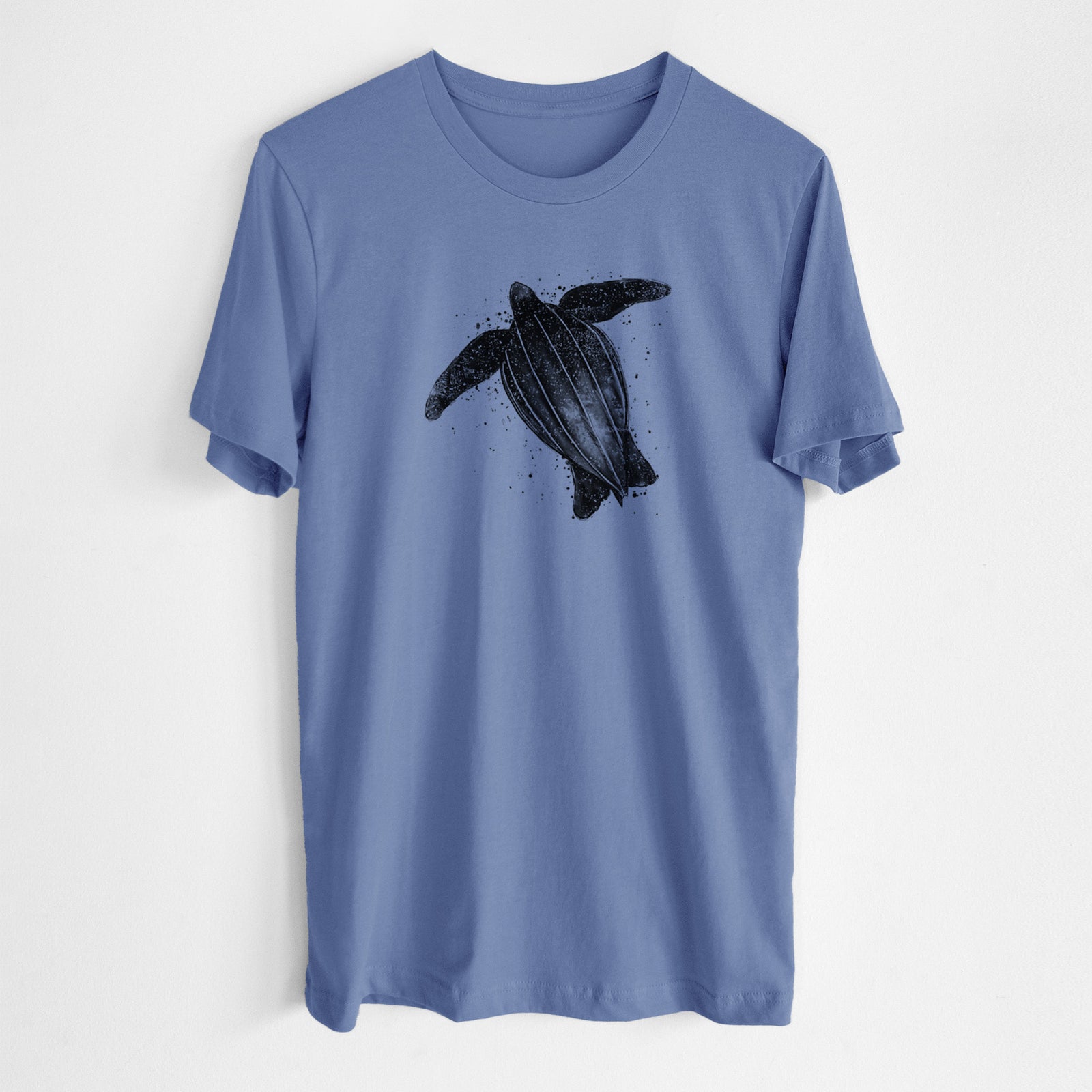 Blue bell lightweight cotton t-shirt laid flat, printed with a black ink illustration of a leatherback sea turtle swimming, with ink splatters.