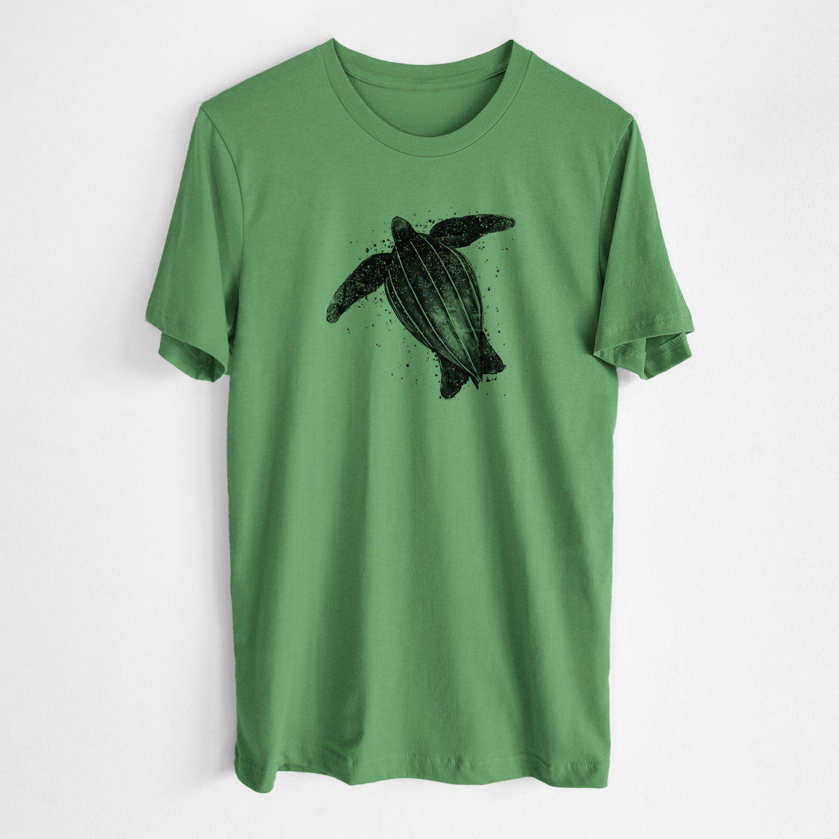 Leaf green lightweight cotton t-shirt laid flat, printed with a black ink illustration of a leatherback sea turtle swimming, with ink splatters.