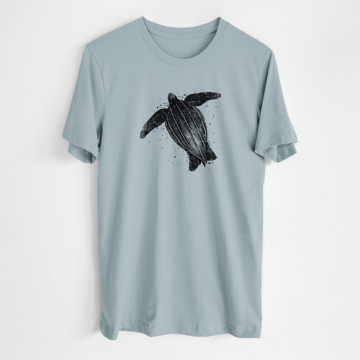 Vintage denim lightweight cotton t-shirt laid flat, printed with a black ink illustration of a leatherback sea turtle swimming, with ink splatters.