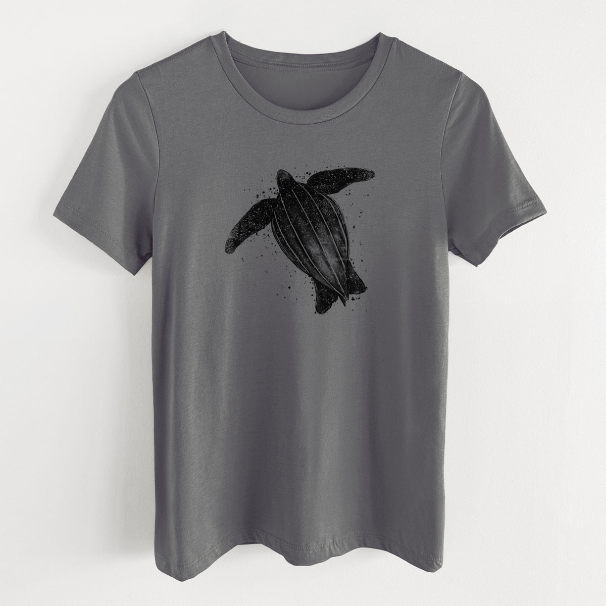 Asphalt women's relaxed fit cotton t-shirt laid flat, printed with a black ink illustration of a leatherback sea turtle swimming, with ink splatters.