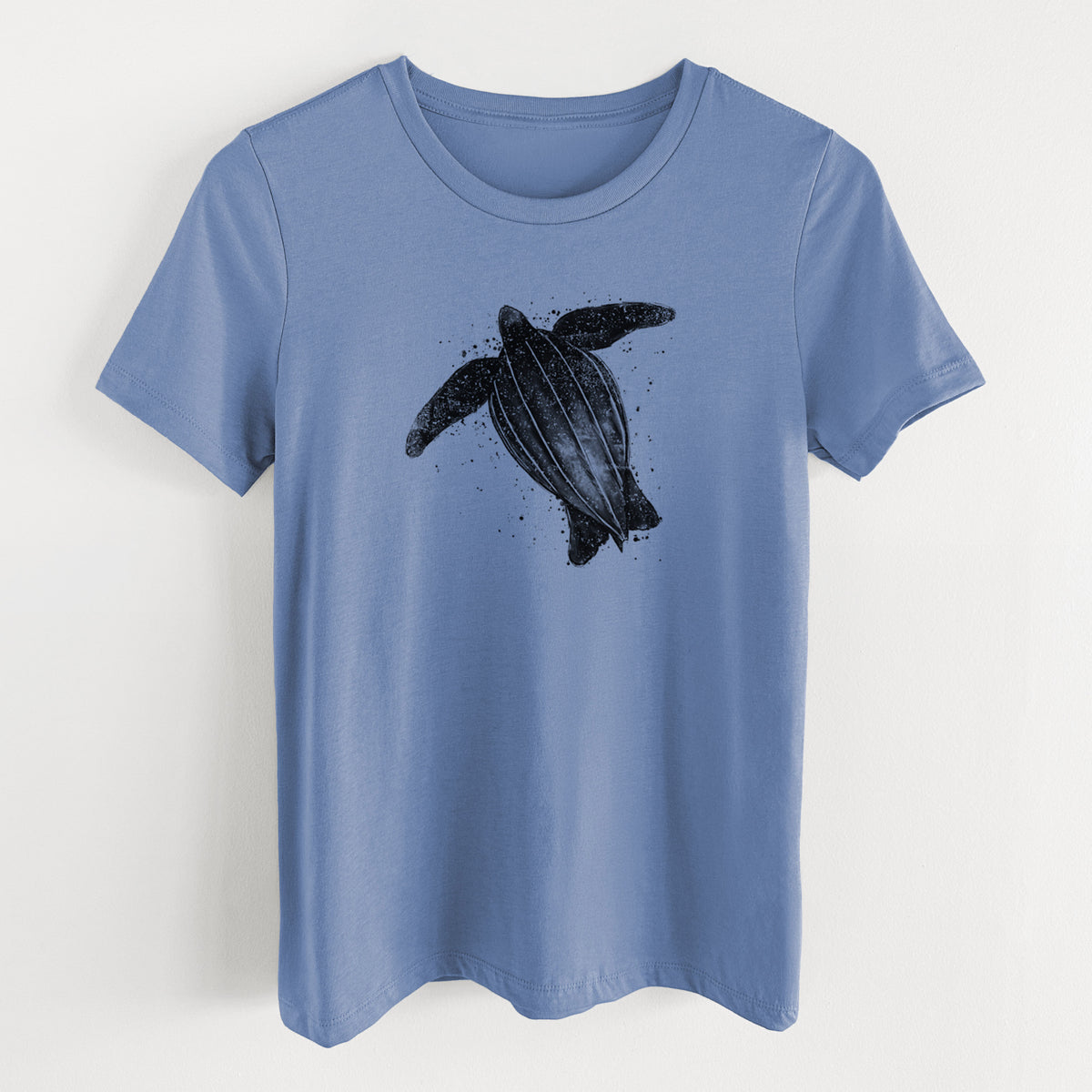 Blue bell women's relaxed fit cotton t-shirt laid flat, printed with a black ink illustration of a leatherback sea turtle swimming, with ink splatters.