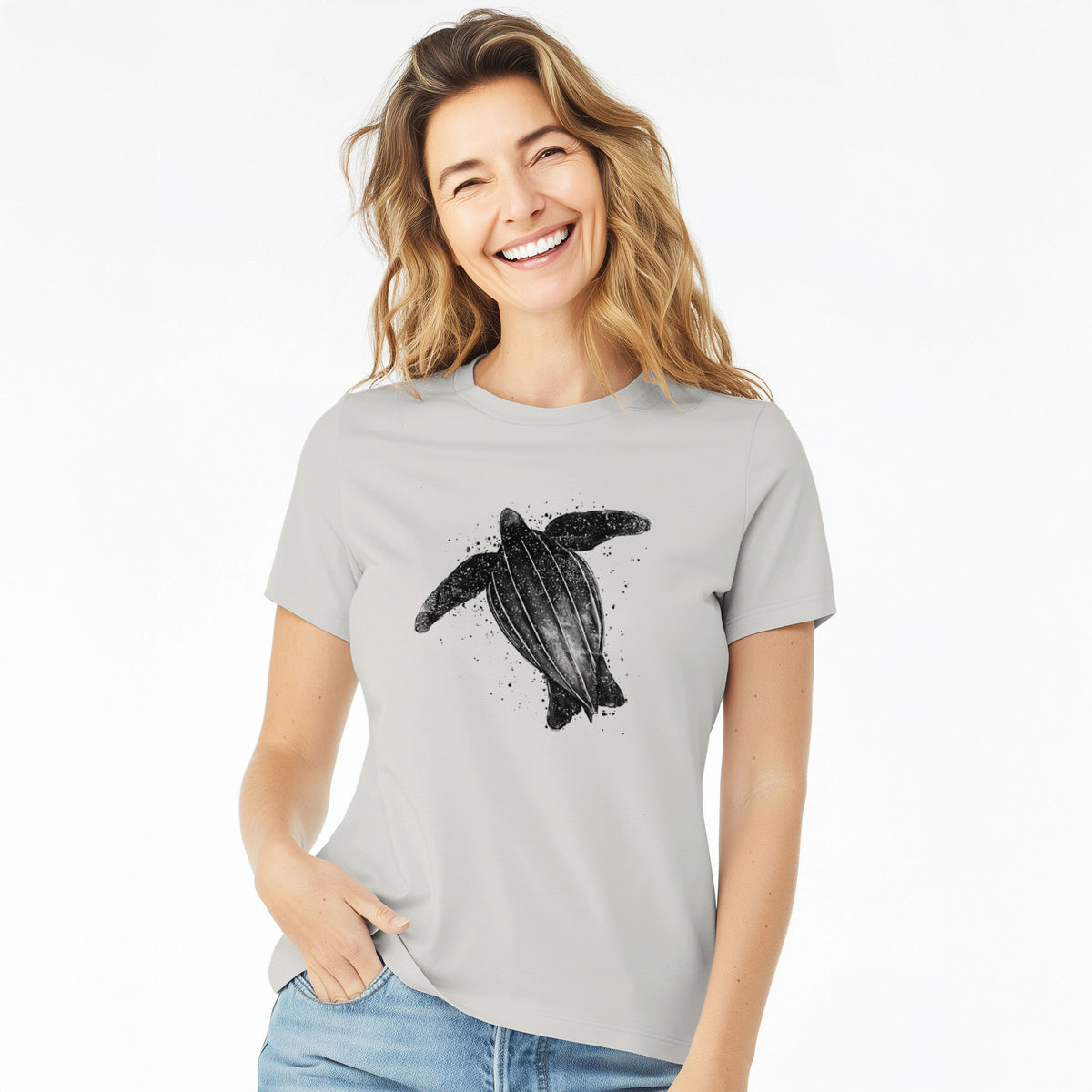 Woman wearing a lunar grey women's relaxed fit cotton t-shirt printed with a black ink illustration of a leatherback sea turtle swimming, with ink splatters.