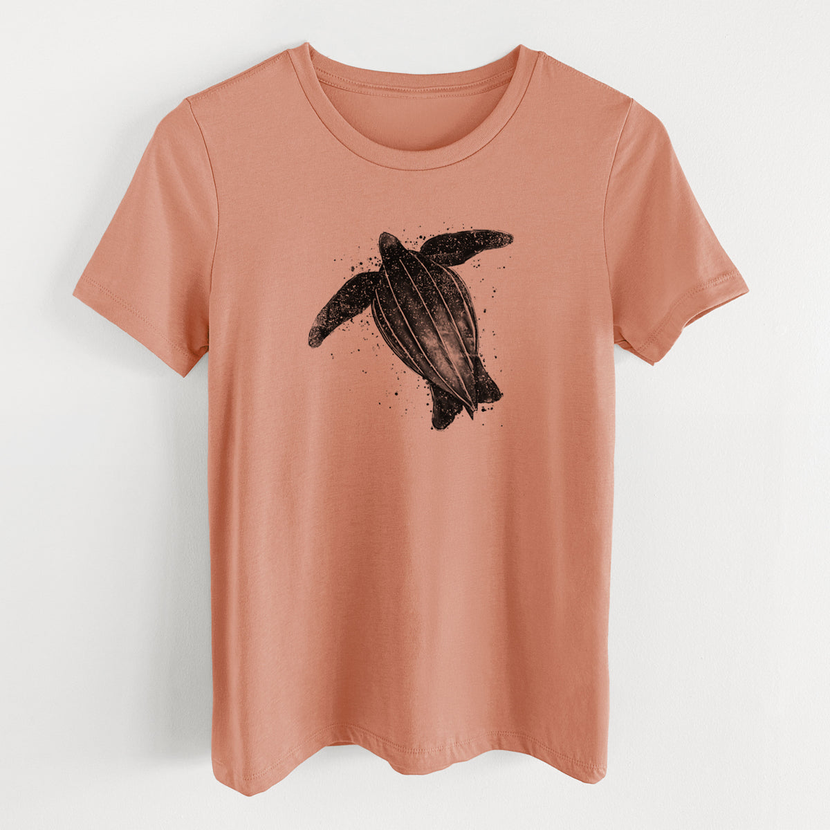 Terracotta orange women's relaxed fit cotton t-shirt laid flat, printed with a black ink illustration of a leatherback sea turtle swimming, with ink splatters.