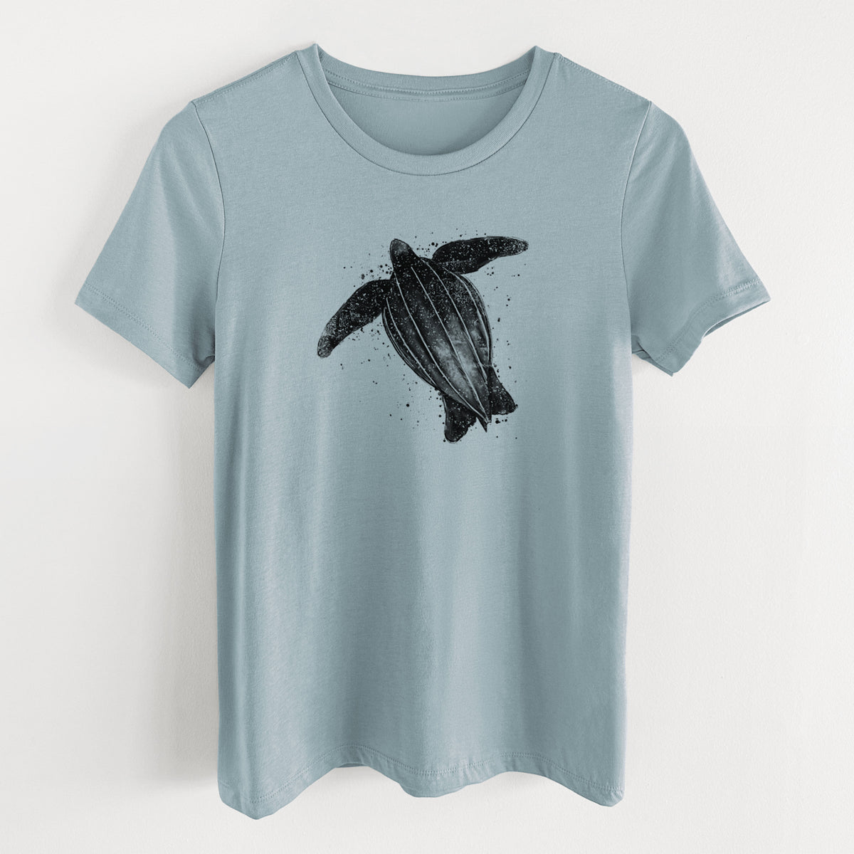 Vintage denim women's relaxed fit cotton t-shirt laid flat, printed with a black ink illustration of a leatherback sea turtle swimming, with ink splatters.