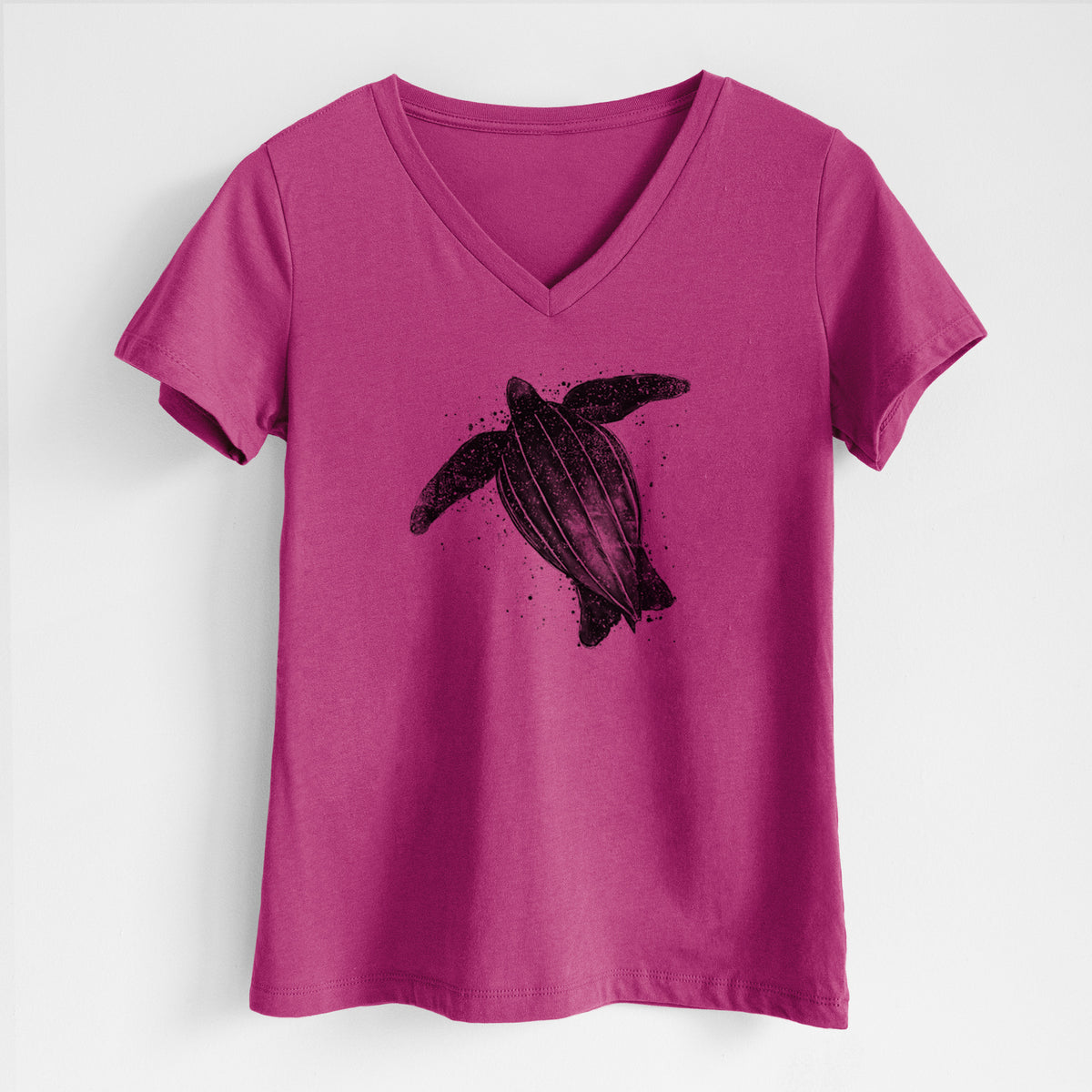 Berry pink women's relaxed fit cotton V-neck t-shirt laid flat, printed with a black ink illustration of a leatherback sea turtle swimming, with ink splatters.