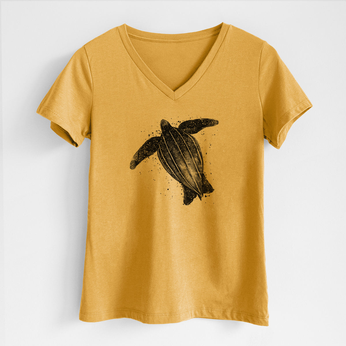 Honeycomb yellow women's relaxed fit cotton V-neck t-shirt laid flat, printed with a black ink illustration of a leatherback sea turtle swimming, with ink splatters.