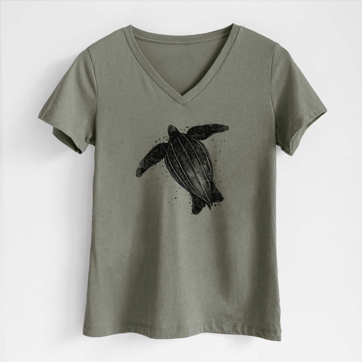 Military green women's relaxed fit cotton V-neck t-shirt laid flat, printed with a black ink illustration of a leatherback sea turtle swimming, with ink splatters.