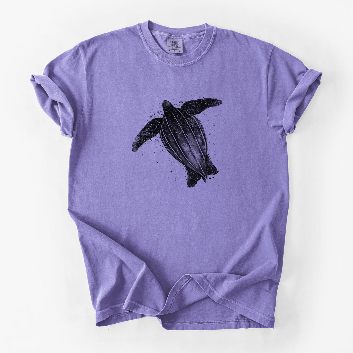 Violet purple Comfort Colors t-shirt laid flat, printed with a black ink illustration of a leatherback sea turtle swimming, with ink splatters.