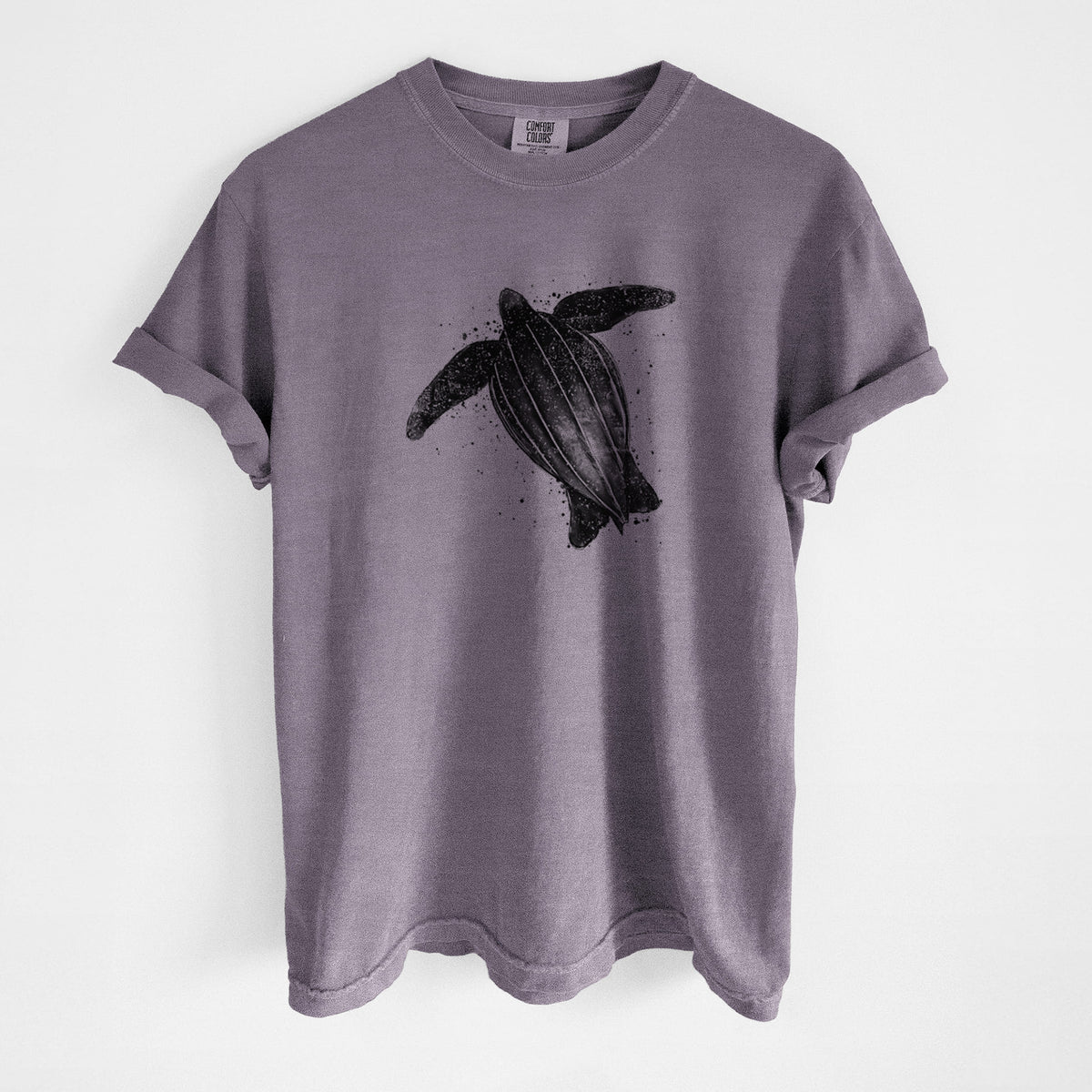 Wine red Comfort Colors t-shirt laid flat, printed with a black ink illustration of a leatherback sea turtle swimming, with ink splatters.