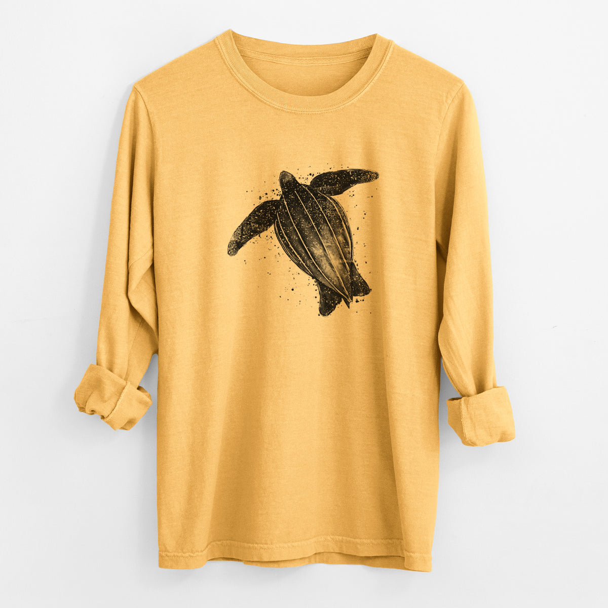 Golden wheat yellow Comfort Colors long sleeve shirt laid flat with the cuffs rolled, printed with a black ink illustration of a leatherback sea turtle swimming, with ink splatters.