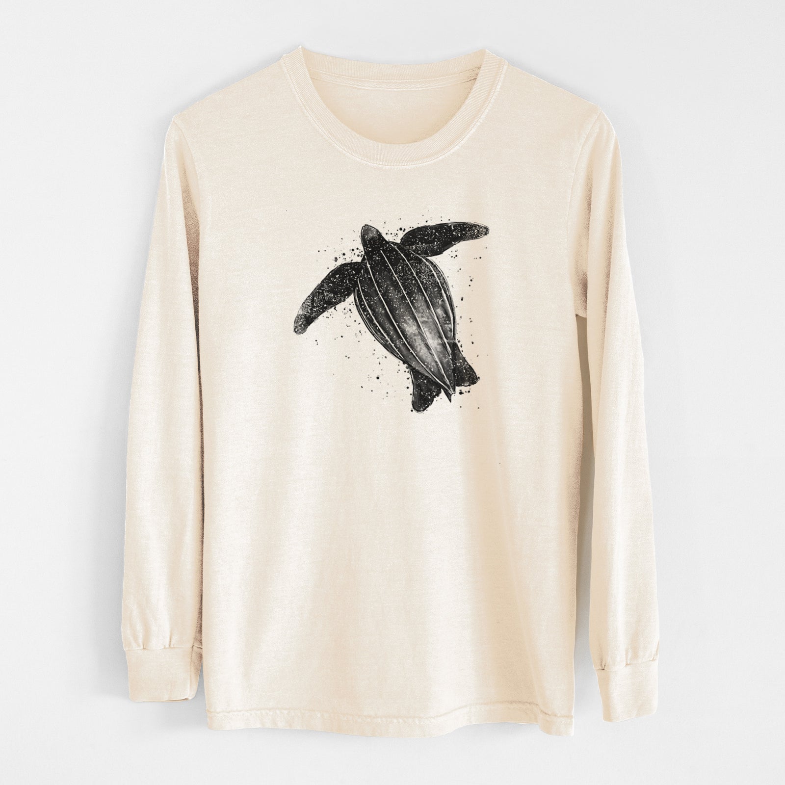 Ivory Comfort Colors long sleeve shirt laid flat, printed with a black ink illustration of a leatherback sea turtle swimming, with ink splatters.