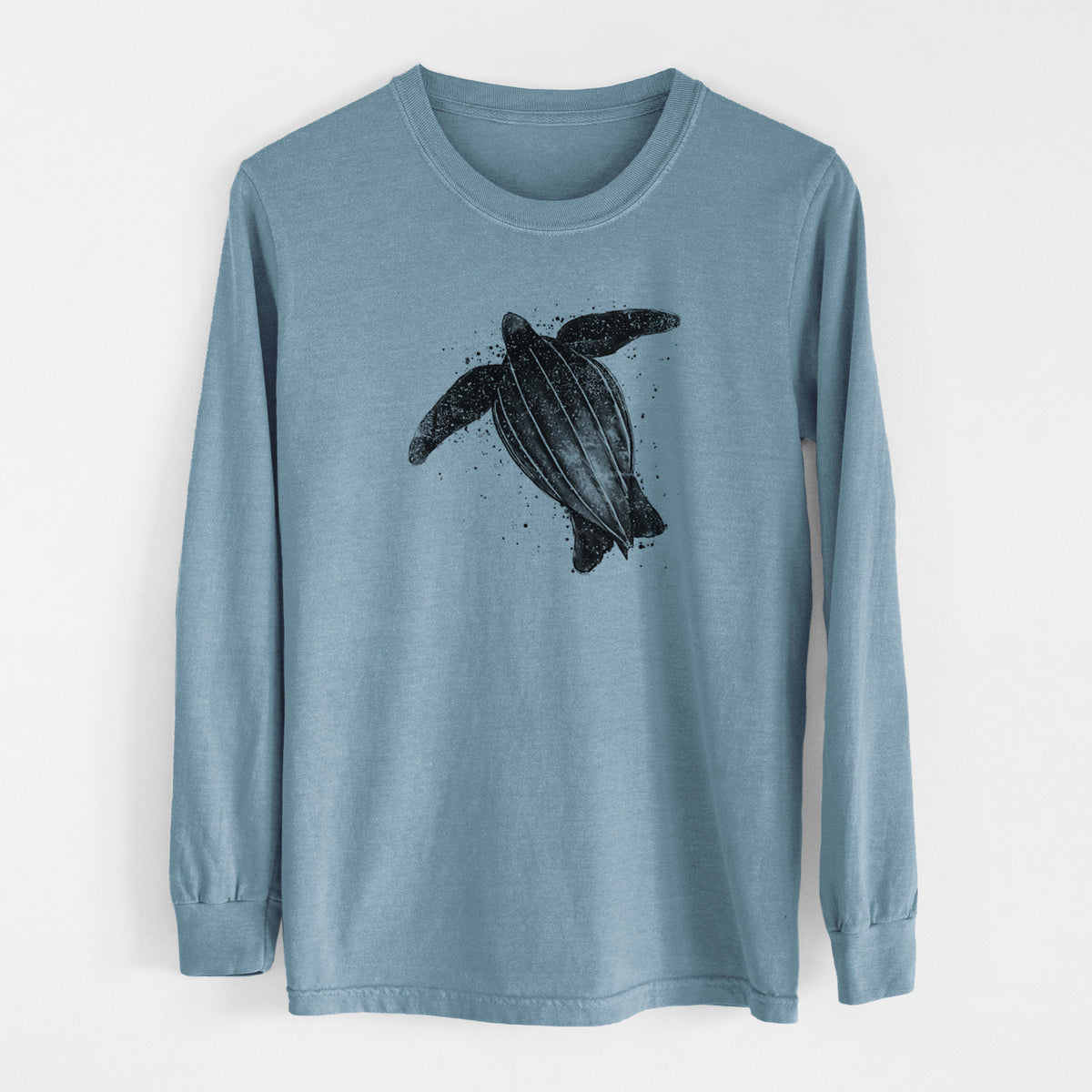 Steel blue Comfort Colors long sleeve shirt laid flat, printed with a black ink illustration of a leatherback sea turtle swimming, with ink splatters.